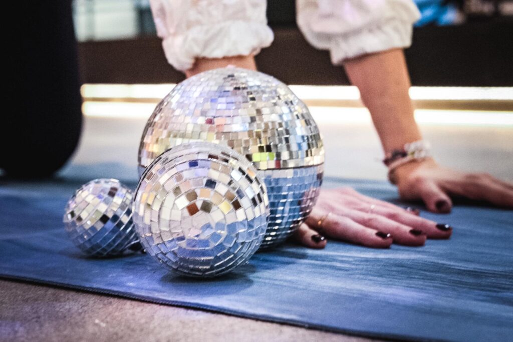 Vier Personen ruhen in der Stellung des Kindes auf Yogamatten in einem hellen Studio.