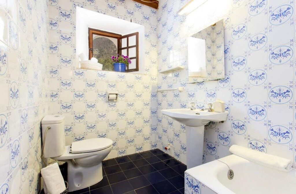 Badezimmer mit blau-weißen Fliesen.